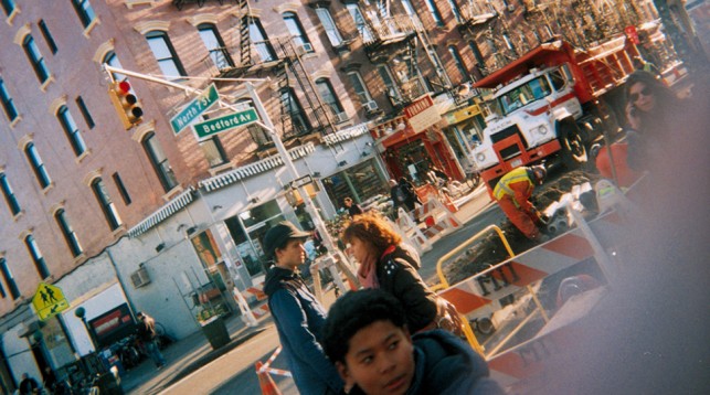 This is a typical day in my 'hood.  Jackhammers, sun streaking the fire escapes and a wide diversity of things happening on the street. I like the young man in the foreground. He looks like he has a diabolical plan.